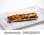 tasty pulled pork sandchich in a chiabatta, on a white background