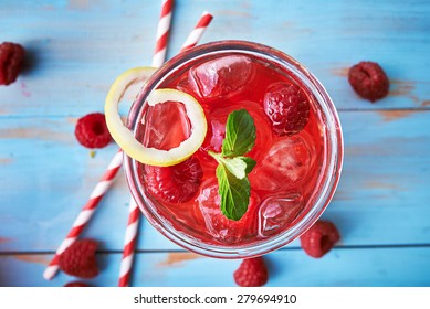 tasty raspberry cocktail with mint and retro paper straws shot from top down