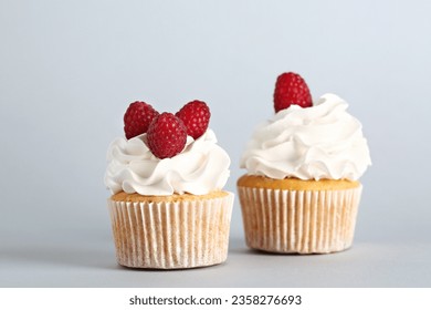 Tasty raspberry cupcakes on grey background - Powered by Shutterstock