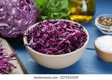 Tasty red cabbage sauerkraut and different ingredients on light blue wooden table - Powered by Shutterstock