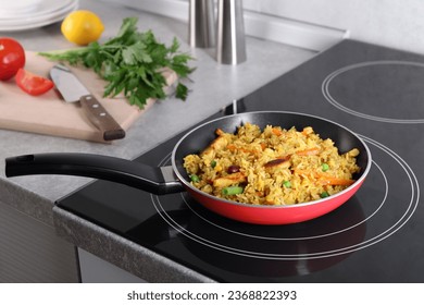 Tasty rice with meat and vegetables in frying pan on induction cooktop - Powered by Shutterstock