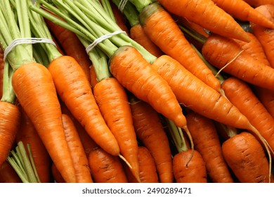 Tasty ripe juicy carrots as background, top view