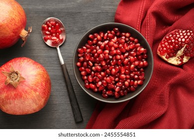 Tasty ripe pomegranates and grains on dark wooden table, flat lay - Powered by Shutterstock