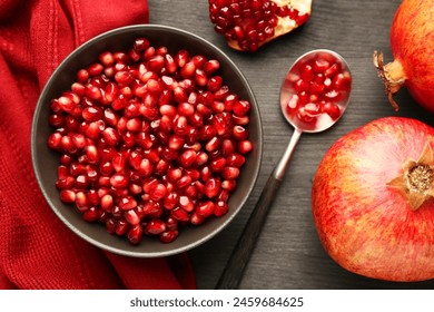 Tasty ripe pomegranates and grains on dark wooden table, flat lay - Powered by Shutterstock