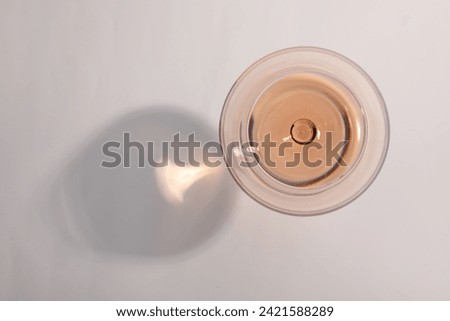 Tasty rose wine in glass isolated on white, top view