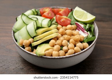 Tasty salad with chickpeas and vegetables on wooden table, closeup - Shutterstock ID 2354114775