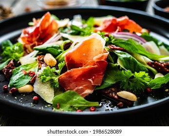 Tasty salad - ham, parmesan and fresh vegetables on wooden background  - Powered by Shutterstock