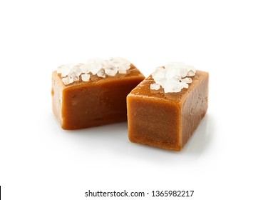 Tasty salty caramel candies on white background