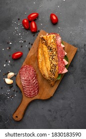 Tasty Sandwich In Baguette With Ham, Sausage And Salami