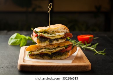 Tasty Sandwich With Meat, Fried Egg, Cheese And Pesto On A Dark Background