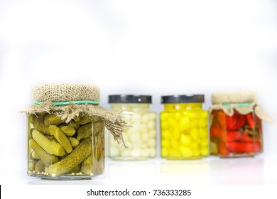 Tasty Seasoned Vegetables In Jars. Kitchen Pantry With Mortar. White Background, Isolated.