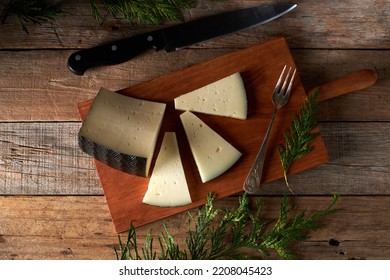 Tasty semi-cured Spanish sheep cheese on rustic wooden table - Shutterstock ID 2208045423