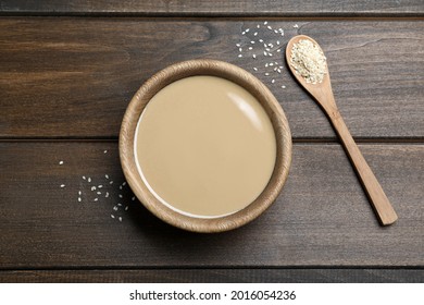 Tasty sesame paste, seeds and spoon on wooden table, flat lay - Shutterstock ID 2016054236