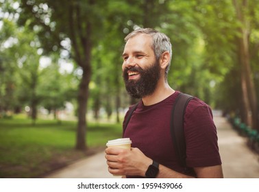 Tasty Sip Concept, Coffee Tea In Paper Cup Close Up. Man Bearded Hipster Enjoy Drink Paper Cup Urban Background. A Handsome Bearded, Gray-haired Guy 30 Years Old Drinks Coffee To Go While Outdoors.