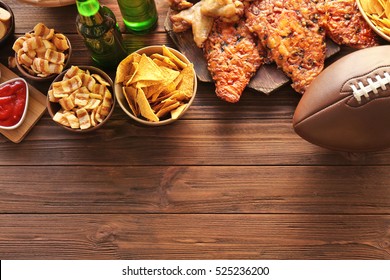 Tasty snacks and rugby ball on wooden table - Powered by Shutterstock