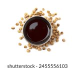 Tasty soy sauce in bowl and soybeans isolated on white, top view