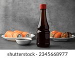 Tasty soy sauce and different types of sushi on grey table
