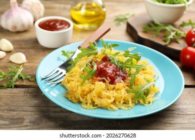 Tasty Spaghetti Squash With Tomato Sauce And Arugula Served On Wooden Table