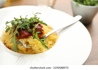 Tasty Spaghetti Squash With Tomato Sauce And Arugula On Table, Closeup