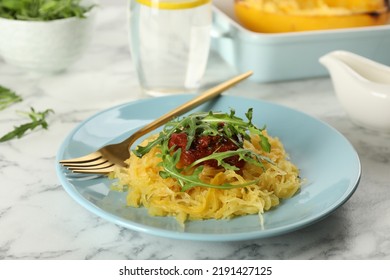 Tasty Spaghetti Squash With Tomato Sauce And Arugula Served On White Marble Table, Closeup