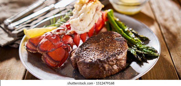 tasty surf & turf steak and lobster meal with asparagus on dinner plate - Shutterstock ID 1512479168