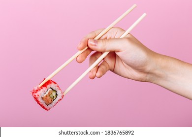 Tasty Sushi Roll California With Wooden Chopsticks On Pink Background Close Up. Place For Caption And Text