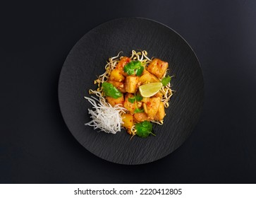 Tasty Sweet And Sour Chicken And Lime In A Black Plate On Dark Background. Top View, Directly Above. Asian Fast Food Oriental Culture Concept, Japanese, Chinese, Thai Cuisine