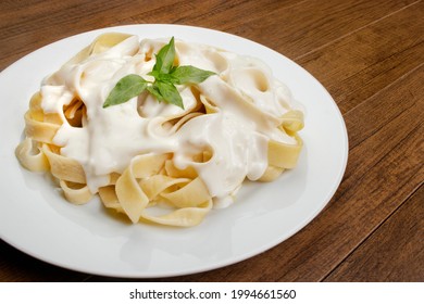 Tasty Tagliatelle Pasta Served With Béchamel Sauce And Basil Leaves. Pasta With White Sauce.