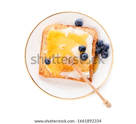 Tasty toasted bread with honey, butter and berries on white background