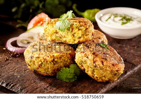 Tasty Turkish falafel patties with chickpea and fava beans served on an old rustic wooden board with salad trimmings Stock photo © 
