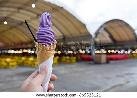 Tasty vanilla ice cream cone in hand, close up. Three large scoops in crispy waffle cornet.