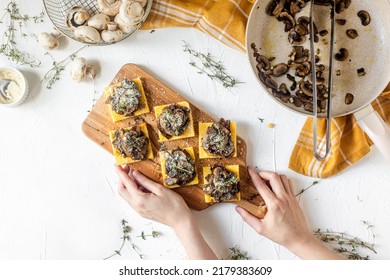 Tasty Vegan Polenta Bites With Cheese And Grilled Mushrooms On A White Table