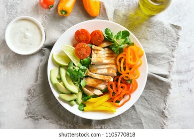 Tasty vegetable salad with grilled chicken breast on stone table. Top view, flat lay