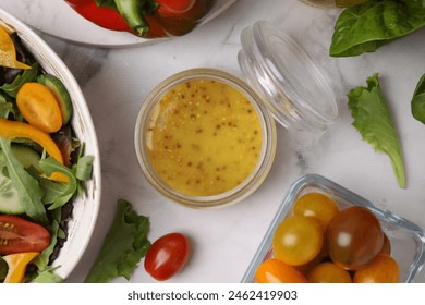 Tasty vinegar based sauce (Vinaigrette) in jar, salad and products on white marble table, flat lay - Powered by Shutterstock