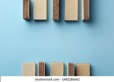 Tasty wafer sticks on blue background, flat lay with space for text. Sweet food