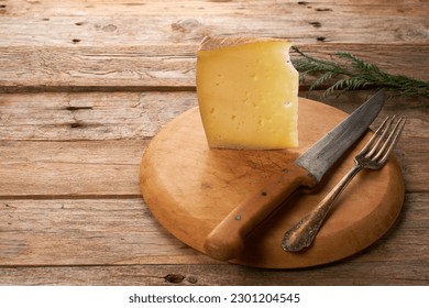 Tasty wedge Spanish Manchego cheese on rustic wooden table - Powered by Shutterstock