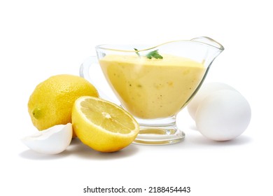Tasty yellow hollandaise sauce in glass bowl gravy boat isolated on white background