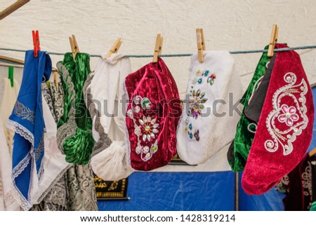 Tatar and Bashkir female traditional vintage hats hang for sale on clothespins on a rope. The annual national holiday of the Tatars and Bashkirs Sabantuy in the city park.