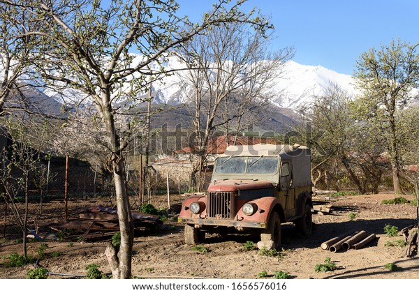 Tatev, Armenia-May, 01 2019: Old russian jeep,\
sturdy motor vehicle with four-wheel drive, rural all-terrain car\
in yard. Armenia, Tatev