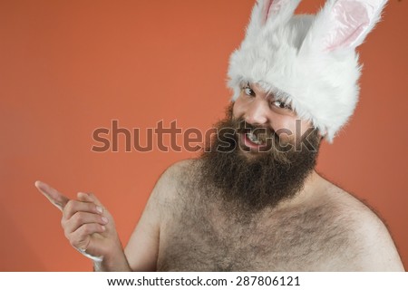 Tattling bearded fat man wears silly bunny ears