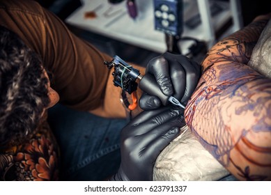 Tattoo Artist Create Tattoo In Tatoo Salon./Professional Tattooist Makes Tattoo In Tattoo Parlor.