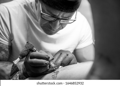 Tattoo Artist Doing A Tattoo. Portrait During The Work Process. Tattoo Concept.