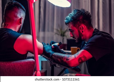 Tattoo Artist Doing Tattoo In Tatoo Salon. Master Makes Tattoo In Tattoo Studio