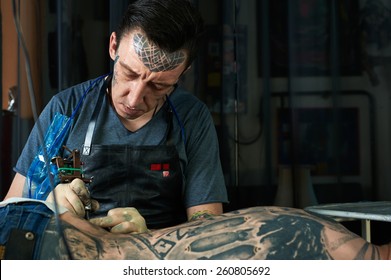 Tattoo Artist Drawing A Tattoo On The Back Of A Guy