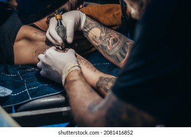 Tattoo Artist Hands Wearing Black Gloves And Holding A Tattoo Machine