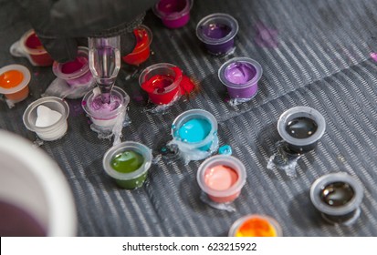 Tattoo artist mixing colors into small cup for ink. Closeup - Powered by Shutterstock