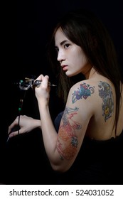 Tattoo Asian Woman Artist Holding Tattoo Machine On Dark Background