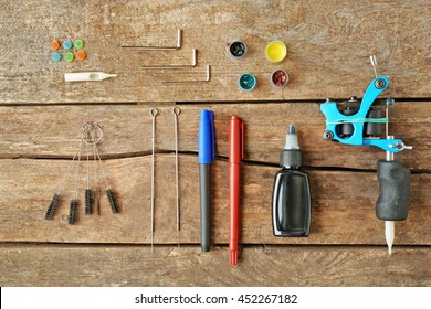 Tattoo Machine And Supplies On Wooden Background