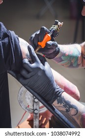 Tattoo master makes tattoo in tattoo studio. Tattoo on hand. Close up