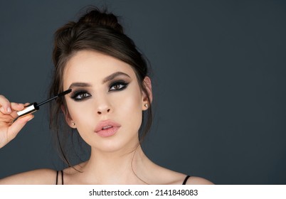 Tattoo, microblading, modeling brows, perfection concept. Gorgeous charming lady with ideal face, healthy shiny clear skin, amazing hairstyle, holds brush in hand, paint her eyebrows - Shutterstock ID 2141848083